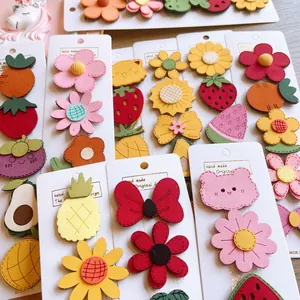 Detail of assorted cute felt hair clips featuring fruit and animal embroidery on card