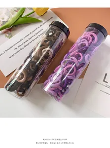Close-up of two clear bottles filled with colorful high-elastic hair ties for girls