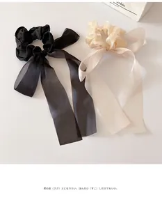 Detail of long sheer organza scrunchies in classic black and champagne with elegant ribbons