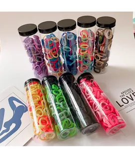 Bulk set of candy-colored elastic hair ties in transparent storage jars with lids