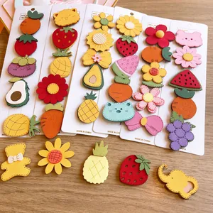 Close-up of handmade felt hair clips with cute fruit and animal shapes for toddlers