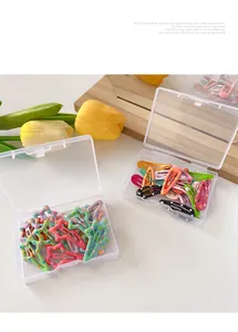 Macro shot of colorful polka dot star and water drop hair clips in transparent storage boxes
