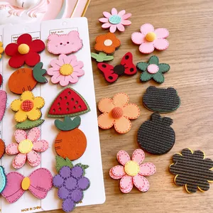 Handmade cartoon fabric hair clips set with cute flowers and fruit shapes on wood table