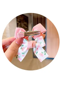 Detail of sweet pink fabric and floral bow hair clips with metal alligator grip