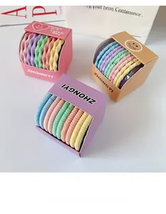 Détail d'élastiques cheveux spirale colorés dans des boîtes roses mauves et jaunes