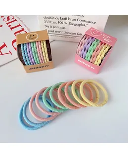 Détail macro d'élastiques à cheveux macarons colorés dans de petites boîtes cadeaux