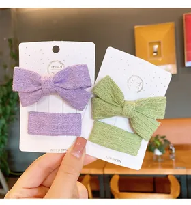 Detail of handmade knitted purple and green bow hair clips for girls on display card