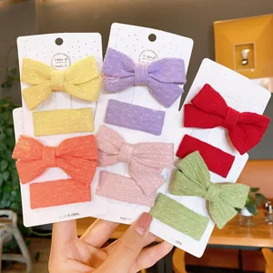 Handmade knitted bow hair clips set for toddlers in various bright colors on white card