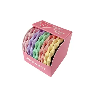 Lot de chouchous élastiques pastels dans une boîte rose avec motif de cœur