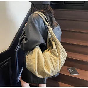 Λεπτομέρεια της χακί πλισέ τσάντας tote με μεγάλη χωρητικότητα και ρυθμιζόμενη αγκράφα