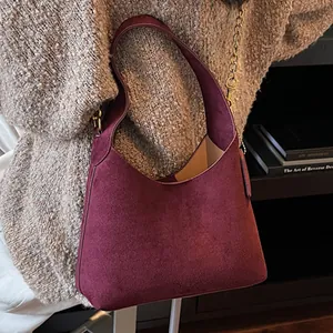 Μεγάλη μπορντό hobo τσάντα από σουέτ φορεμένη πάνω από ένα casual πλεκτό πουλόβερ