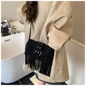 Détail du sac à franges en daim noir avec boucle métallique et bandoulière élégante