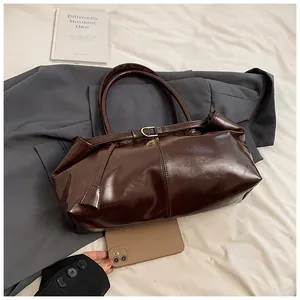 Λεπτομέρεια vintage σκούρα καφέ τσάντα tote από γυαλιστερό δέρμα με μεταλλική αγκράφα