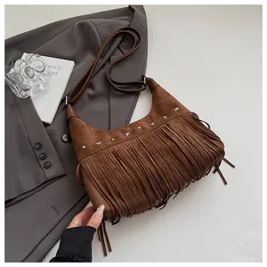Vue de dessus d'un sac seau en daim marron avec franges et rivets sur un blazer