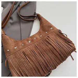 Gros plan du sac seau à franges en daim marron avec rivets étoiles argentés et franges