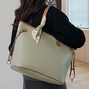 Chic green pebbled leather tote bag with brown straps and silk scarf, shoulder view