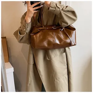 Λεπτομέρεια της vintage καφέ τσάντας tote με αγκράφα ζώνης και υφή δέρματος στον ώμο
