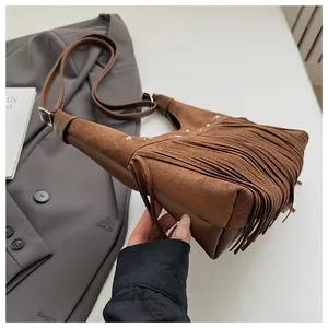 Détails du sac seau en daim marron avec franges, clous et bandoulière réglable
