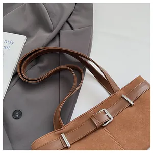 Λεπτομέρεια vintage καφέ τσάντας tote με υφή σουέτ και δερμάτινο λουρί με αγκράφα