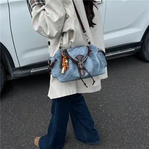 Sac seau vintage en tissu bleu avec garniture en cuir marron et pendentif perlé