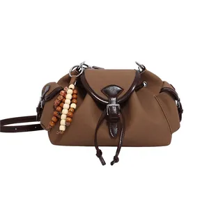 Sac seau en toile marron avec garniture en cuir et pompons en perles de bois