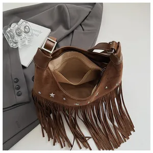 Détail du sac seau en daim marron avec franges, clous étoiles et poche intérieure zippée