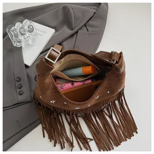Détail de l'intérieur spacieux du sac seau en daim bohème avec de longues franges