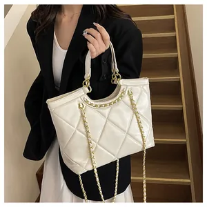 Détail d'un sac à bandoulière en cuir crème matelassé avec une chaîne dorée