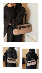 Detail view of suede underarm bag with black leather buckle straps and golden hardware
