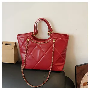 Détail du sac en cuir matelassé rouge avec des accents de chaîne dorée élégants