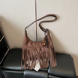 Sac seau vintage en daim marron avec franges, clous étoiles et pompon perlé