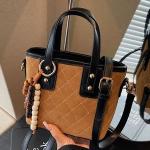 Vintage brown quilted crossbody bucket bag with wooden bead charm and black handles
