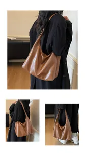Detail einer großen braunen Hobo-Tasche mit verstellbarem Riemen und Ledertextur