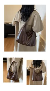 Detail einer dunkelbraunen Hobo-Tasche aus Kunstleder mit Öl-Textur und Trageriemen