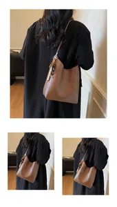 Détail du grand sac cabas en cuir marron vintage avec un accessoire de charme perlé coloré