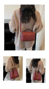 Vue détaillée du sac à bandoulière rouge foncé et du sac seau avec perles et franges