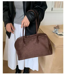 Detalle del bolso Boston de ante marrón oscuro con cremallera metálica y asas largas