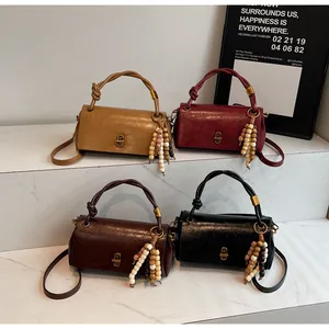 Detailed shot of retro leather handbags featuring knotted handles and beaded tassel charms