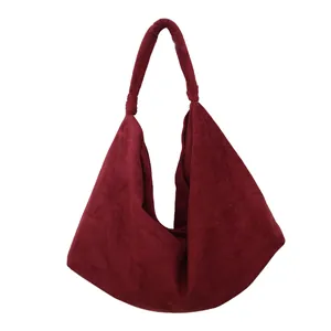 Detail of burgundy suede hobo bag with unique knotted handle and soft triangular shape