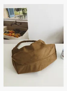 Detail of soft brown suede texture on a minimalist large capacity shoulder tote bag