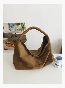Detailed close-up of brown suede hobo bag with a soft texture in a home lifestyle setting