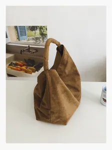 Detail shot of the knotted handle and premium caramel suede texture on large tote bag