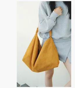 Detail of ginger yellow tote bag showing the knotted shoulder strap and soft suede texture