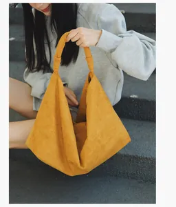 Detail of a ginger yellow canvas tote bag with a minimalist knot handle for casual wear