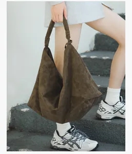 Detail shot of the large dark brown suede tote bag with decorative knot handle design