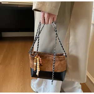 Détail du sac à bandoulière en daim matelassé avec chaîne et perles décoratives