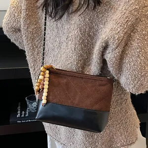 Sac à chaîne matelassé marron avec charme en perles de bois dans un décor cozy