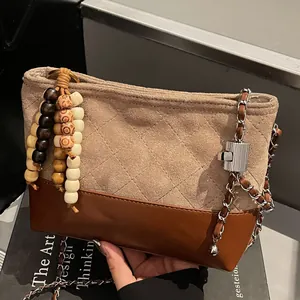Sac seau matelassé rétro bicolore en daim avec pompon en bois et bandoulière chaîne