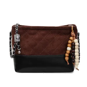 Sac seau matelassé en daim marron et cuir noir avec bandoulière chaîne et pompon