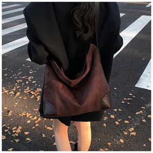 Λεπτομέρεια καφέ σουέτ τσάντας με δερμάτινα μπαλώματα στις γωνίες και ραφές